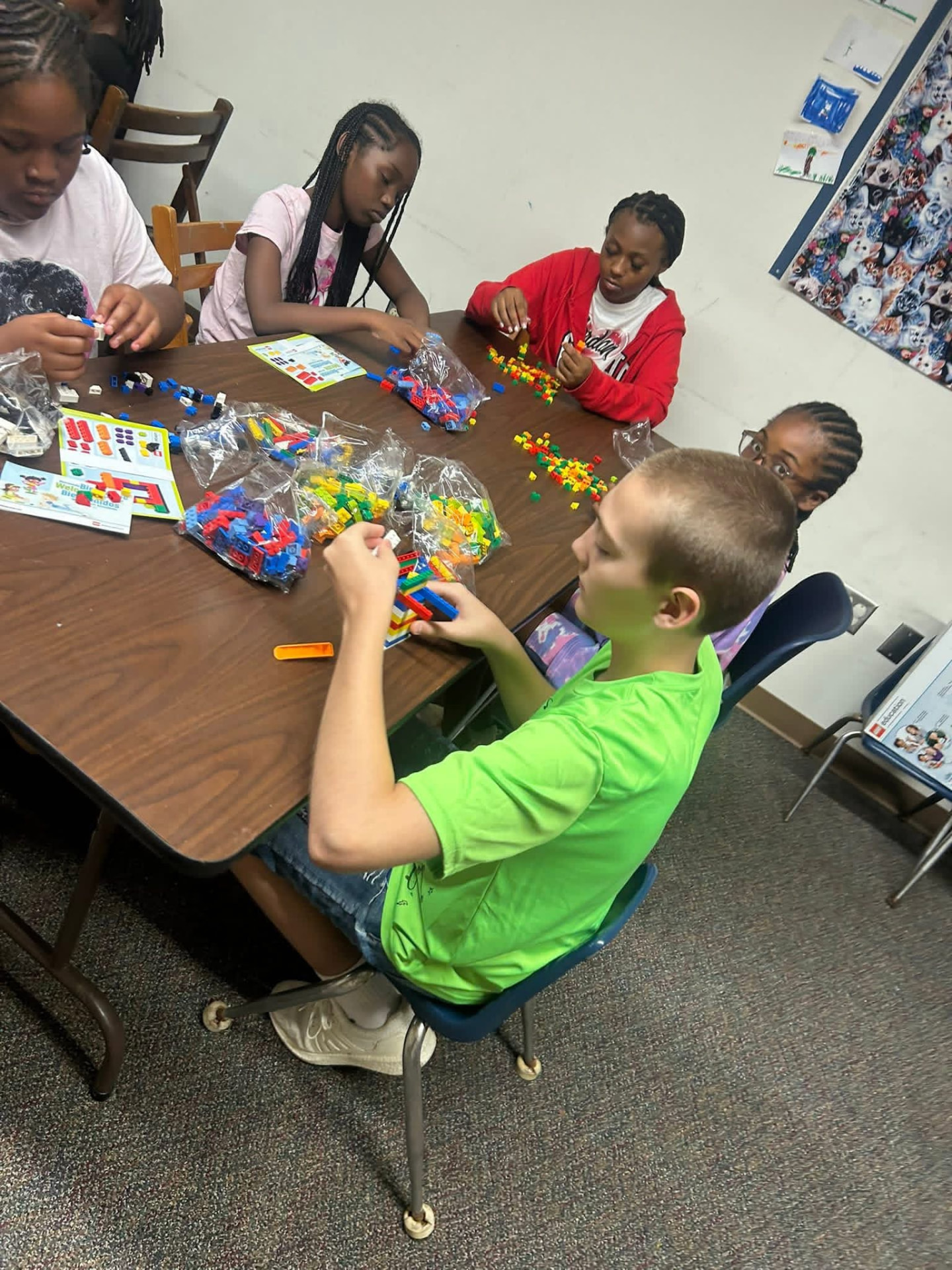 Students building with LEGO bricks at a table