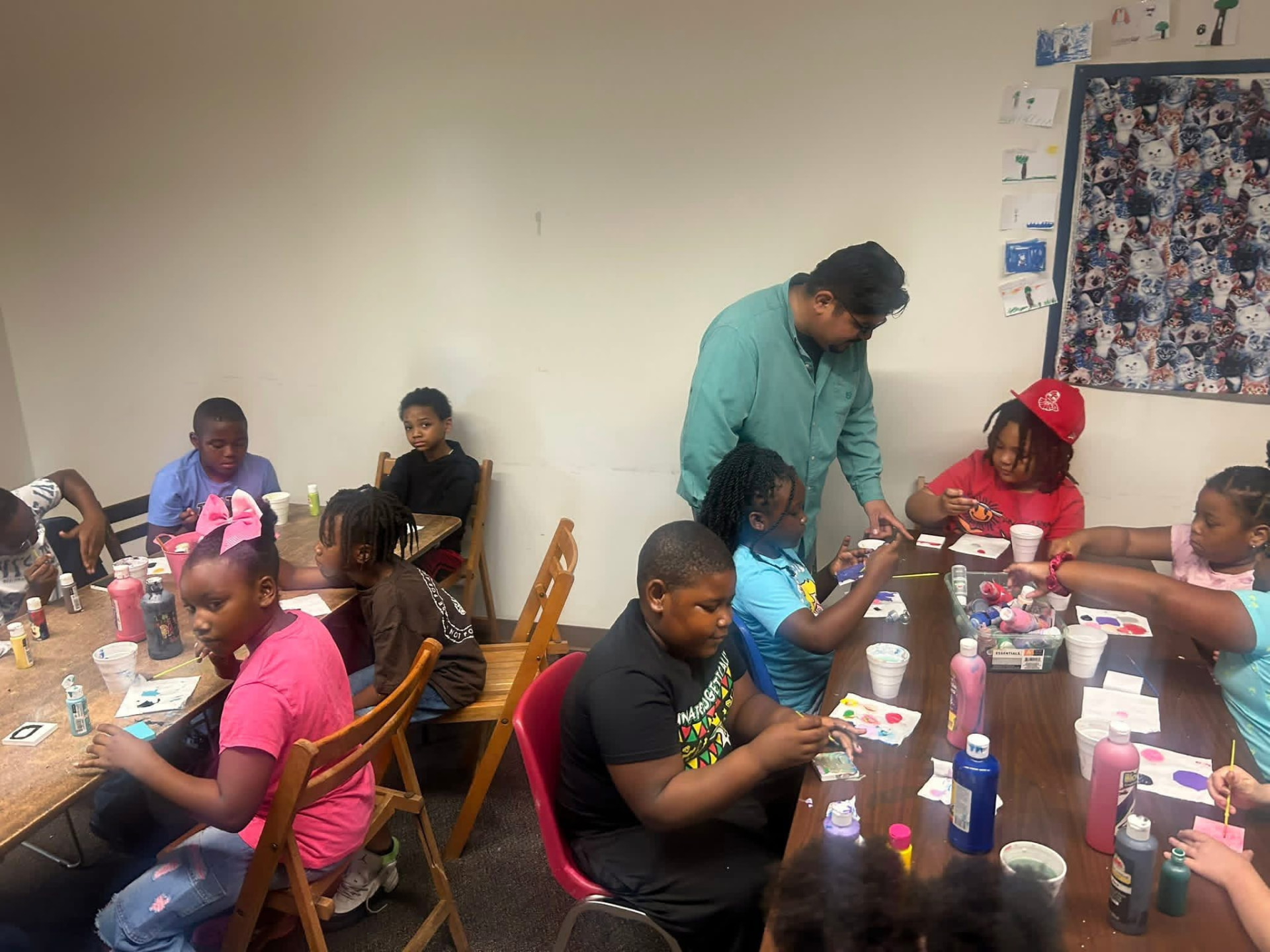 Kids painting and doing crafts around a long table